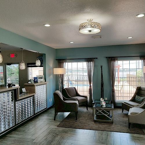 This image shows a modern, well-lit waiting area with stylish furniture, a reception desk, and large windows allowing natural light inside.