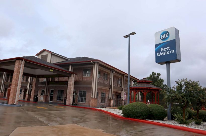 This image shows a Best Western hotel with a sign, a covered entrance, and a gazebo. It appears to be a rainy day.